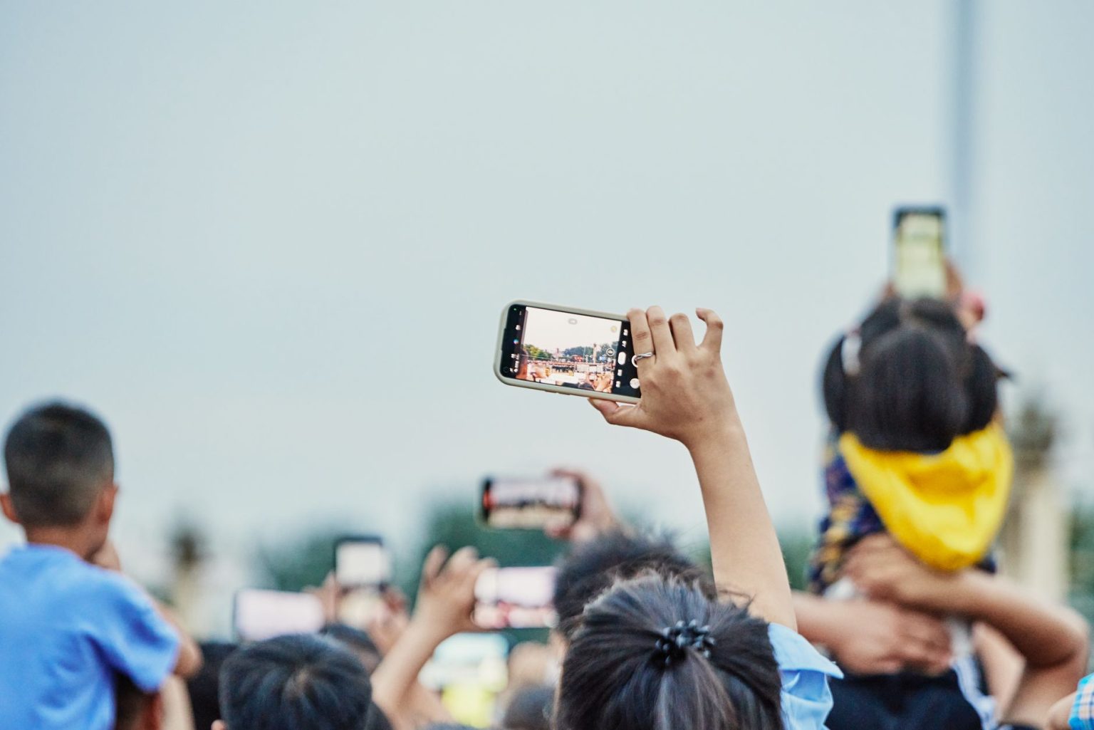 Pessoas reunidas em uma praça usando smartphones durante um evento