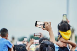 Pessoas reunidas em uma praça usando smartphones durante um evento