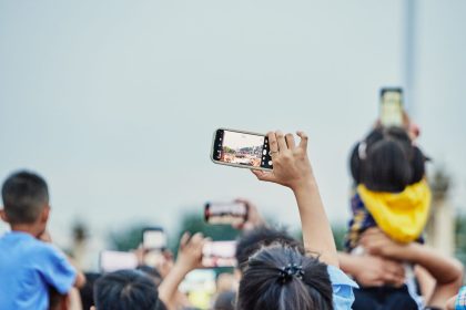 Pessoas reunidas em uma praça usando smartphones durante um evento