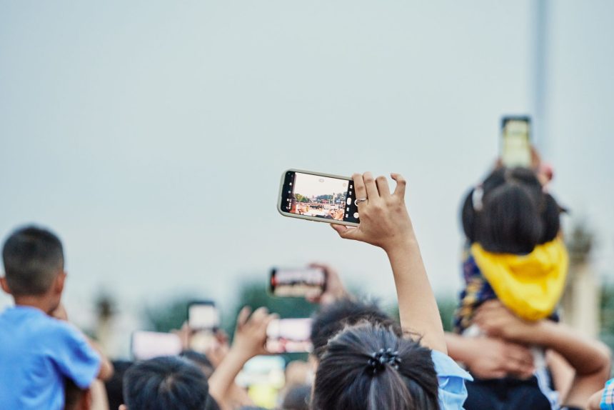 Pessoas reunidas em uma praça usando smartphones durante um evento