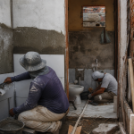 Trabalhadores realizam reforma em uma moradia de área periférica de Fortaleza