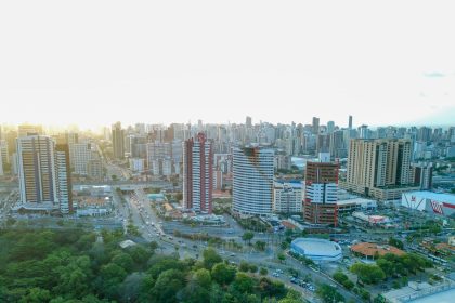Vista aérea do skyline de Fortaleza, com edifícios, áreas verdes e a paisagem urbana da capital cearense