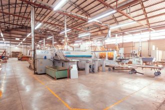 Interior de uma fábrica industrial organizada, com máquinas e equipamentos de produção.