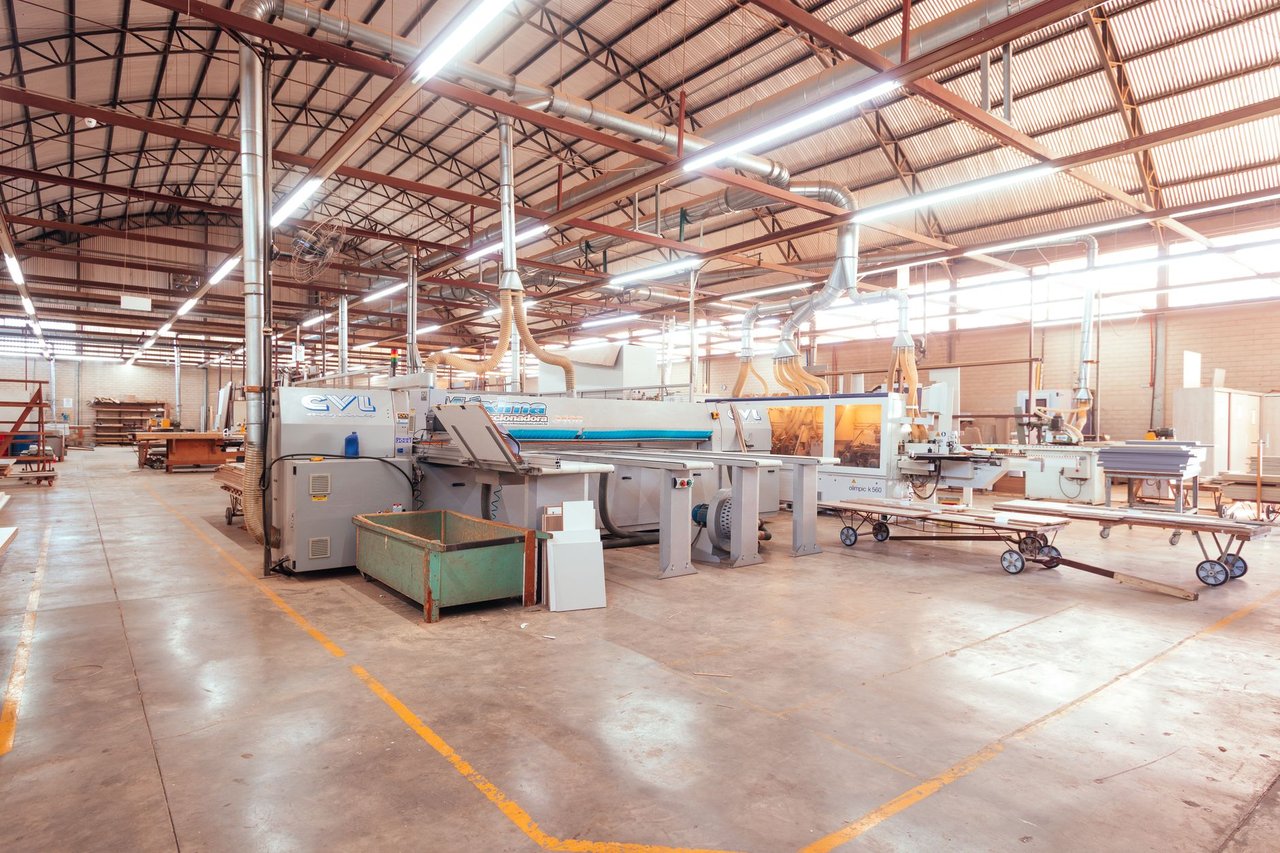 Interior de uma fábrica industrial organizada, com máquinas e equipamentos de produção.