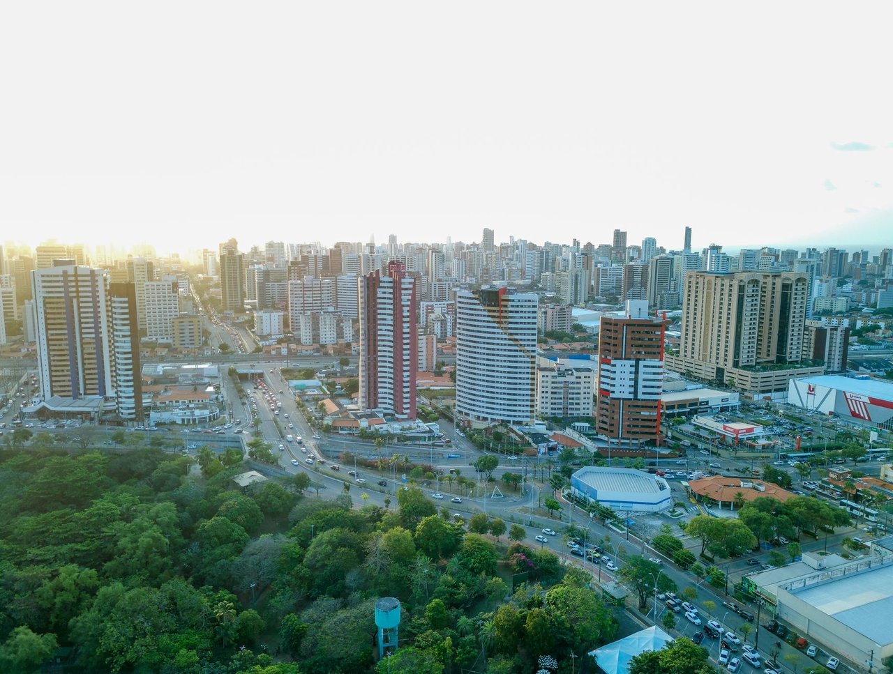 Vista aérea do skyline de Fortaleza, com edifícios, áreas verdes e a paisagem urbana da capital cearense