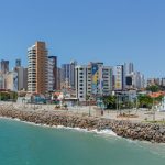 Vista da orla de Fortaleza, no Ceará, com edifícios altos junto à faixa costeira.